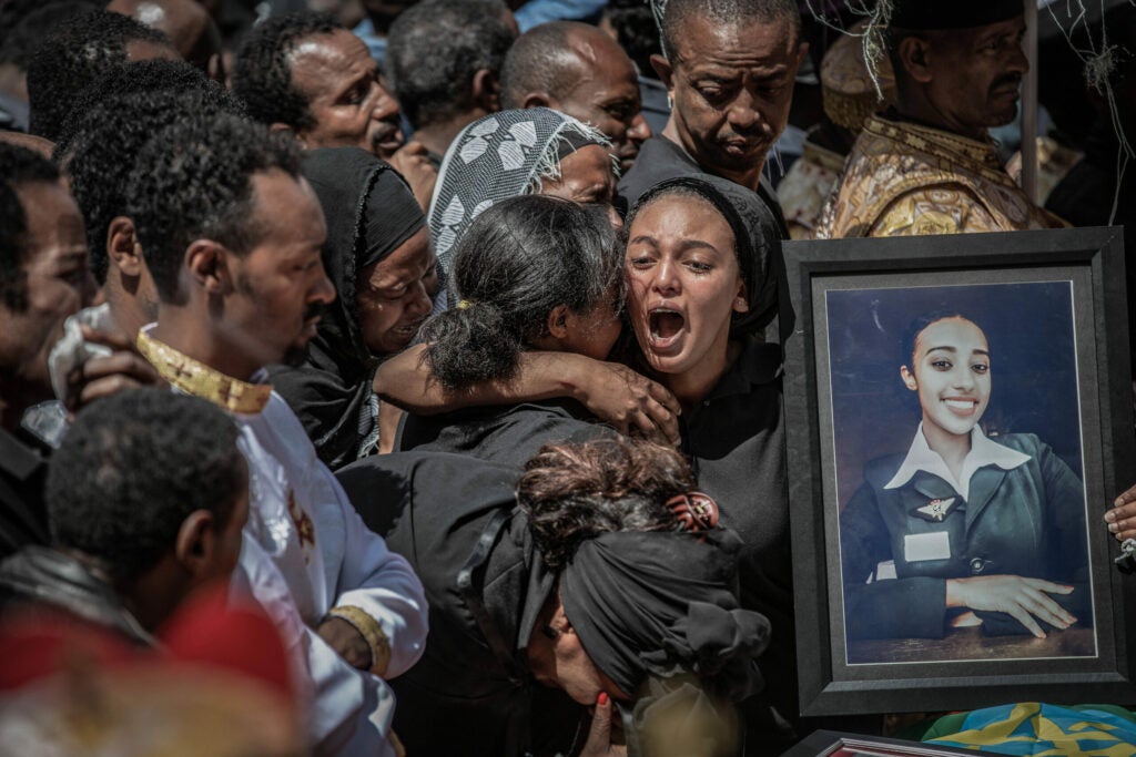 Relatives hold a photograph of a victim of the crash of Ethiopian Airlines Flight ET302 at a mass funeral