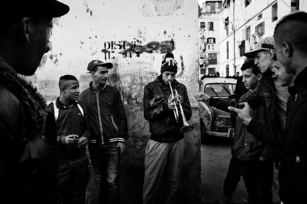 A young man carries a trumpet in Bab el-Oued, Algiers, Algeria,