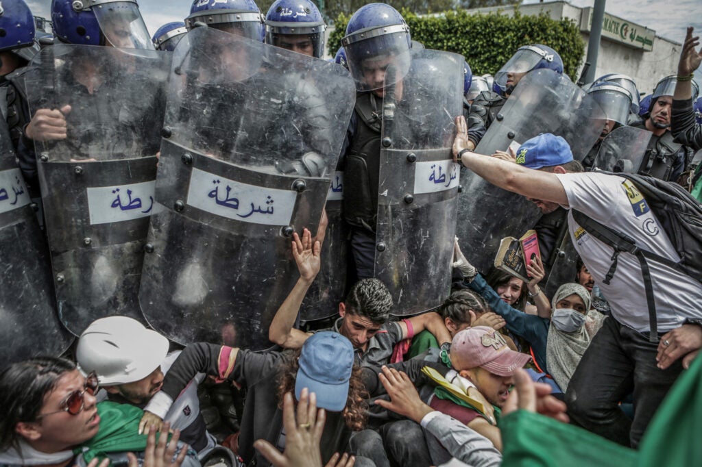 Algerian students and riot police scuffle during an anti-government demonstration. Algeria has been embroiled in an unprecedented wave of months-long protests following the February 2019 announcement of then-President Abdelaziz Bouteflika to seek a fifth term in office.