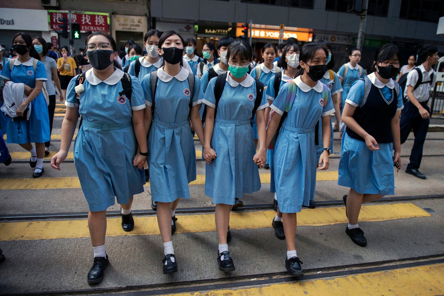 Students cross a road to school after participating in a human-chain rally, in Hong Kong, on 12 September 2019.