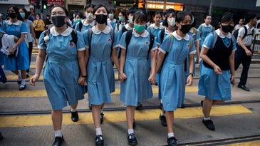 Students cross a road to school after participating in a human-chain rally, in Hong Kong, on 12 September 2019.
