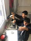 Two students unroll their hand-developed negatives inside the darkroom.