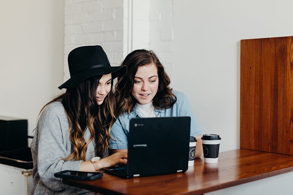 two people behind a computer