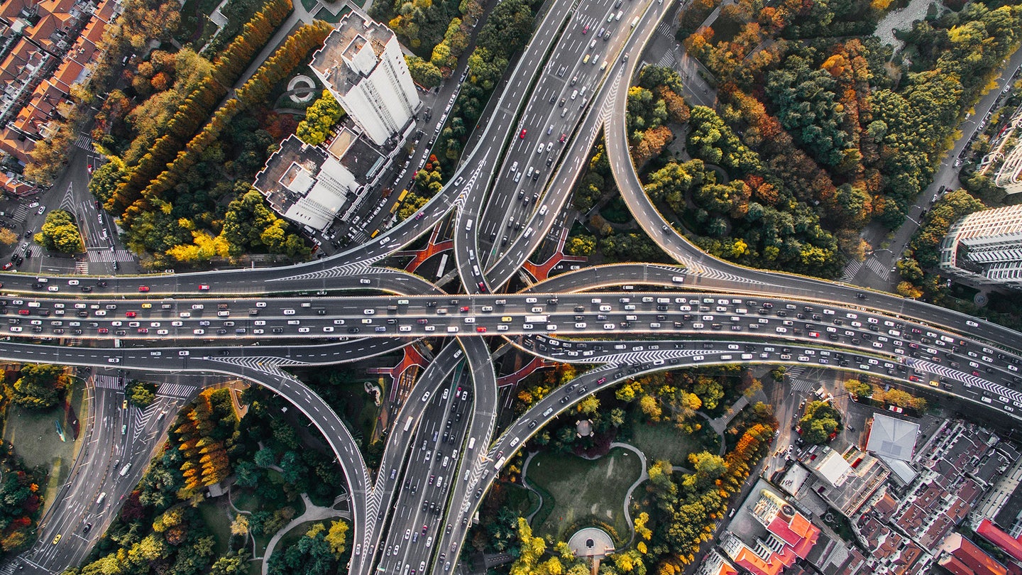 birds-eye view of highway with cars, buildings, and trees