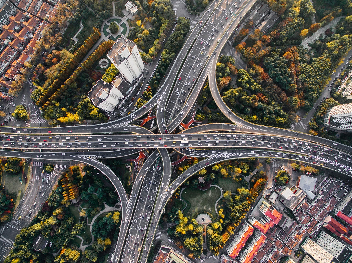birds-eye view of highway with cars, buildings, and trees