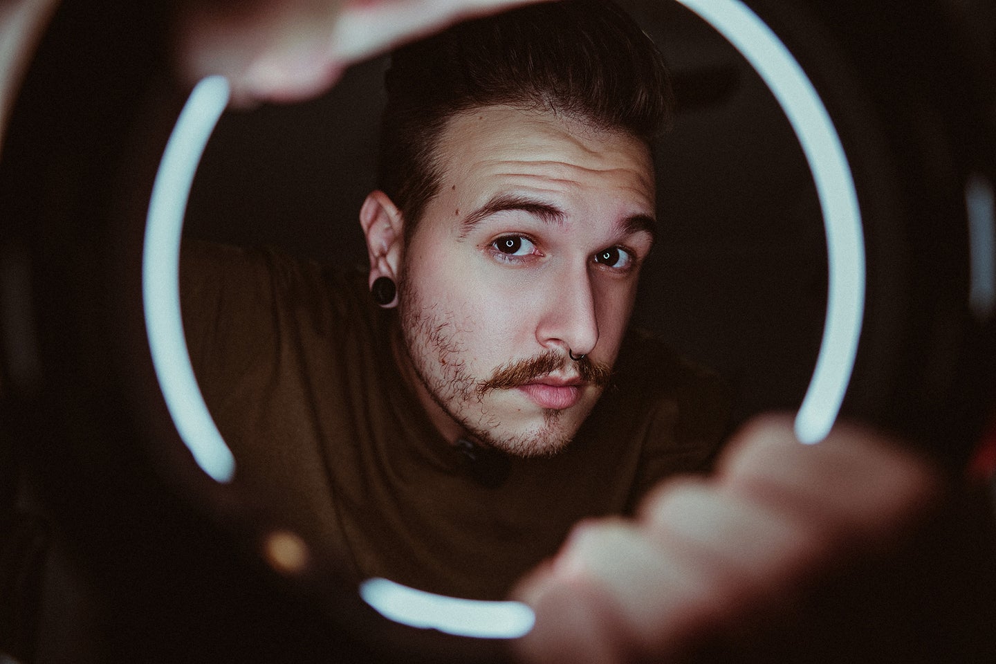 guy with a mustache looking through the best LED ring light