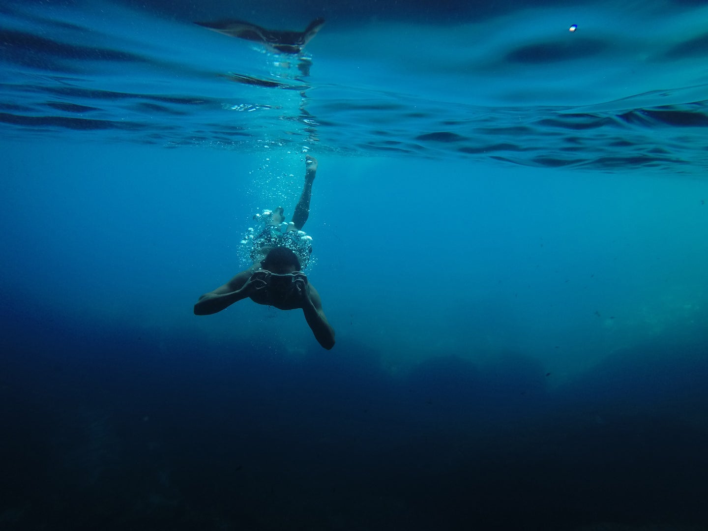 man underwater with the best underwater camera taking a picture