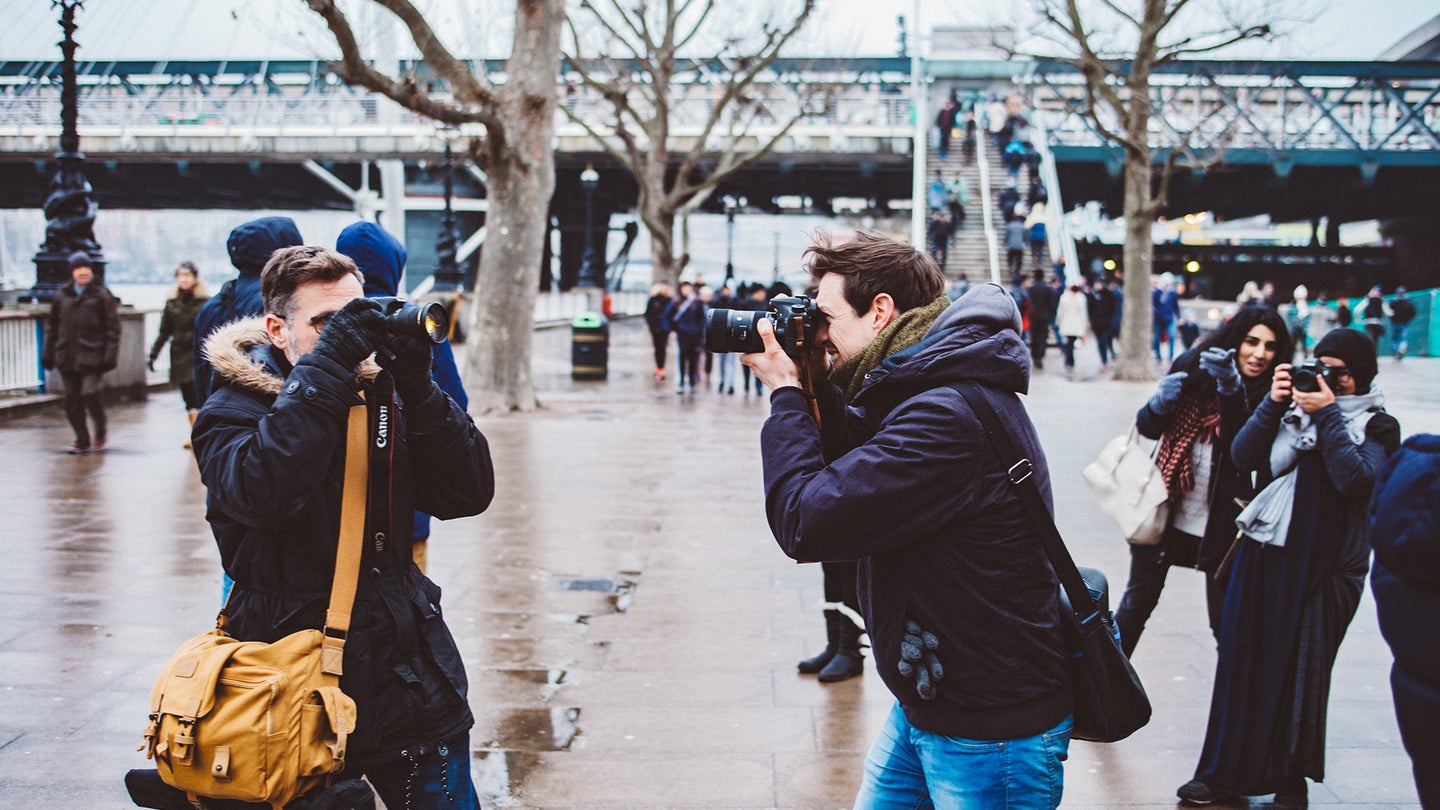 people with cameras and the best camera backpack outside taking photos
