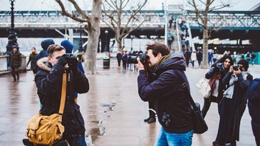 people with cameras and the best camera backpack outside taking photos