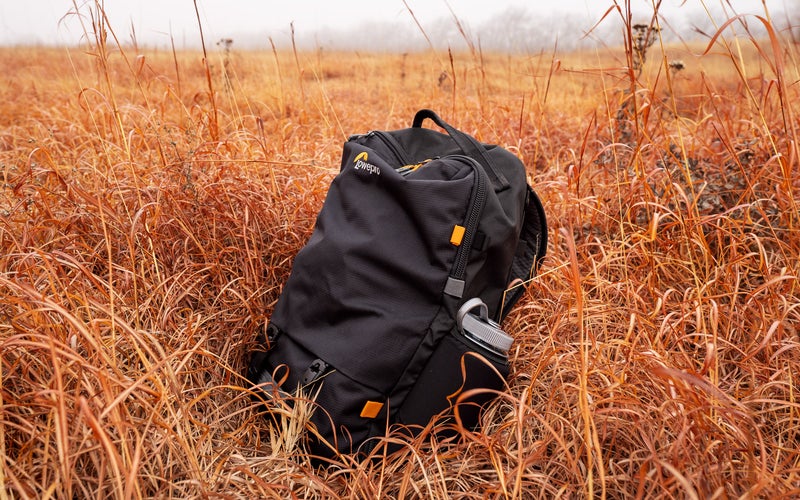 Lowepro Trekker Lite BP 250 AW camera backpack in a field of grass on a foggy day
