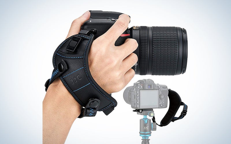 hand holding a camera with a strap
