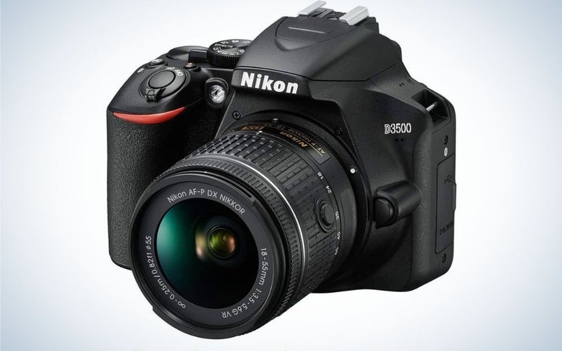 The Nikon D3500, a black-bodied camera with a red stripe around the shutter button, is the best DSLR camera for beginners.