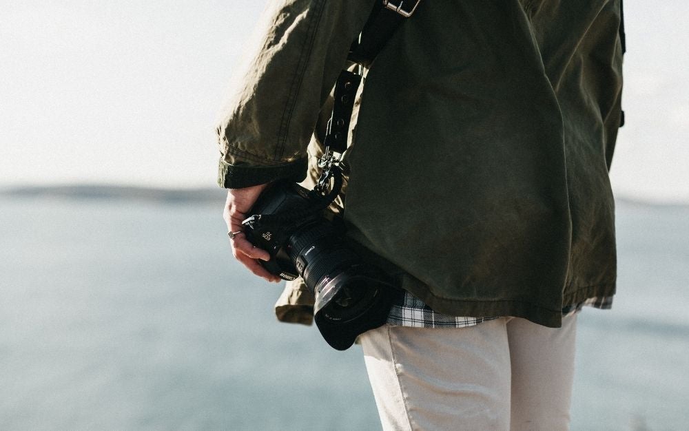 Person using a harness for his black camera