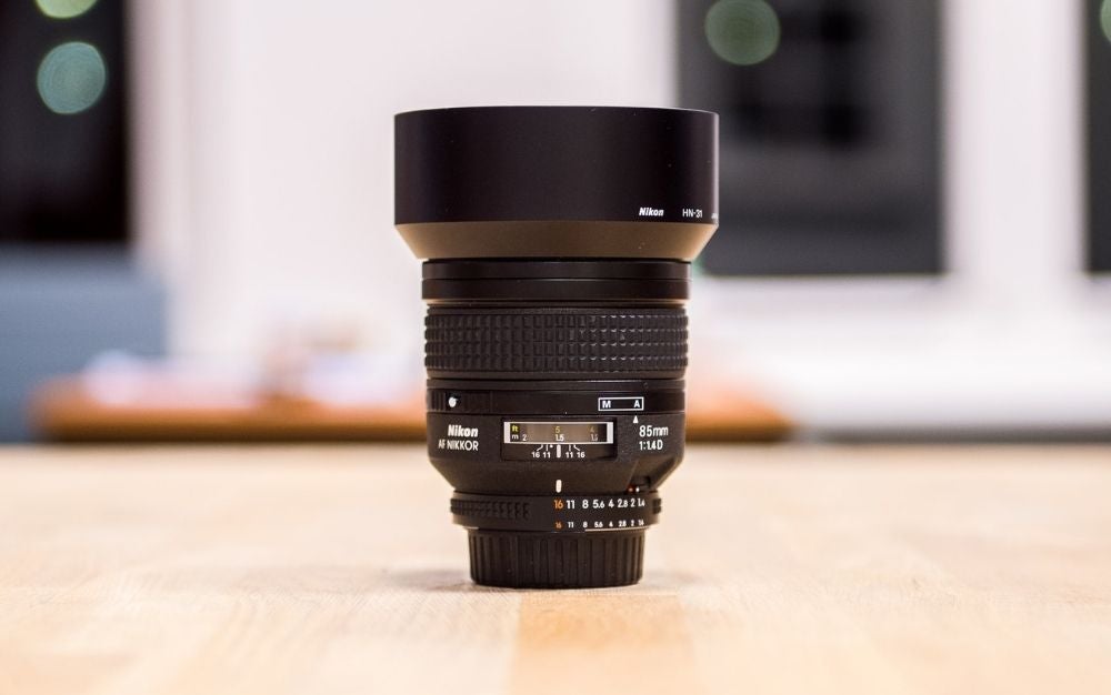 A camera lens standing over a wooden floor upside down.