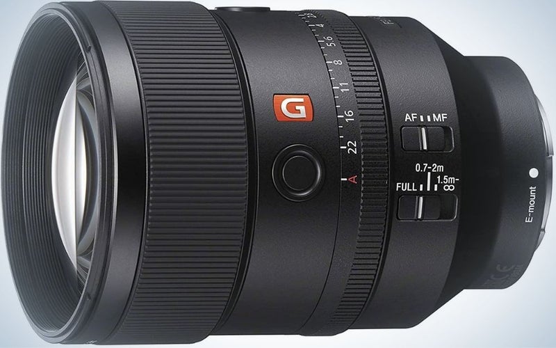 The lens of a professional camera positioned sideways and in a circular shape and with its longer body.