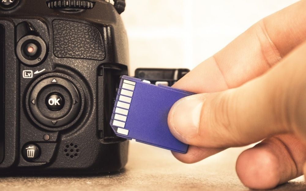 Hand inserting SD card into DSLR camera