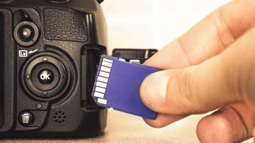 Hand inserting SD card into DSLR camera