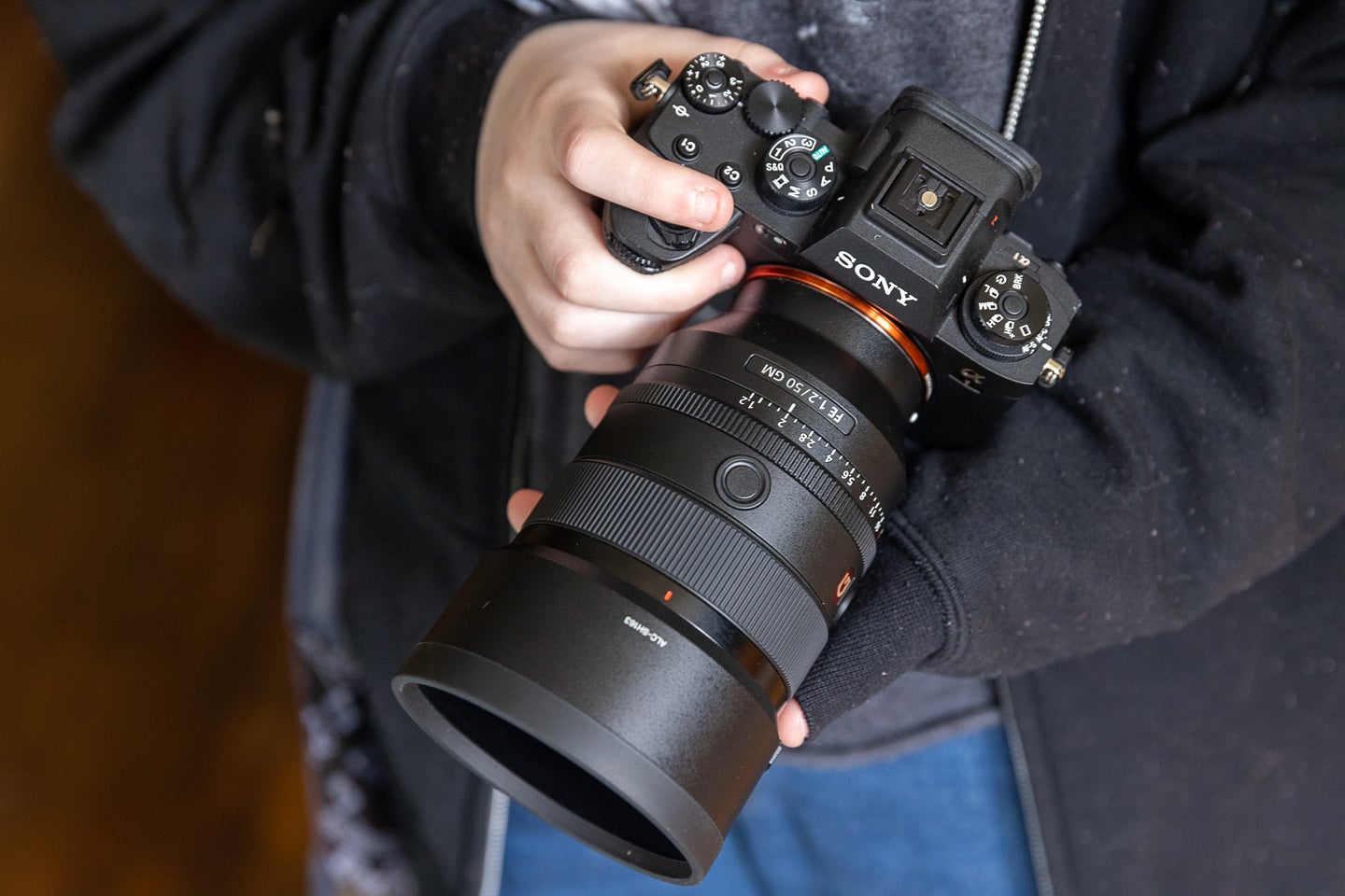 A hand holds the Sony A1 mirrorless camera