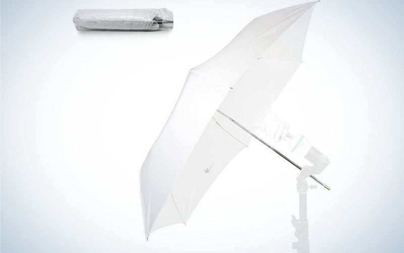 An open white umbrella all with a white stick and a white box on top.