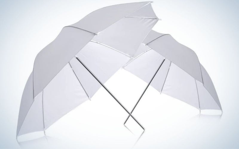 Two open white umbrellas and two thin tails supported by each other.