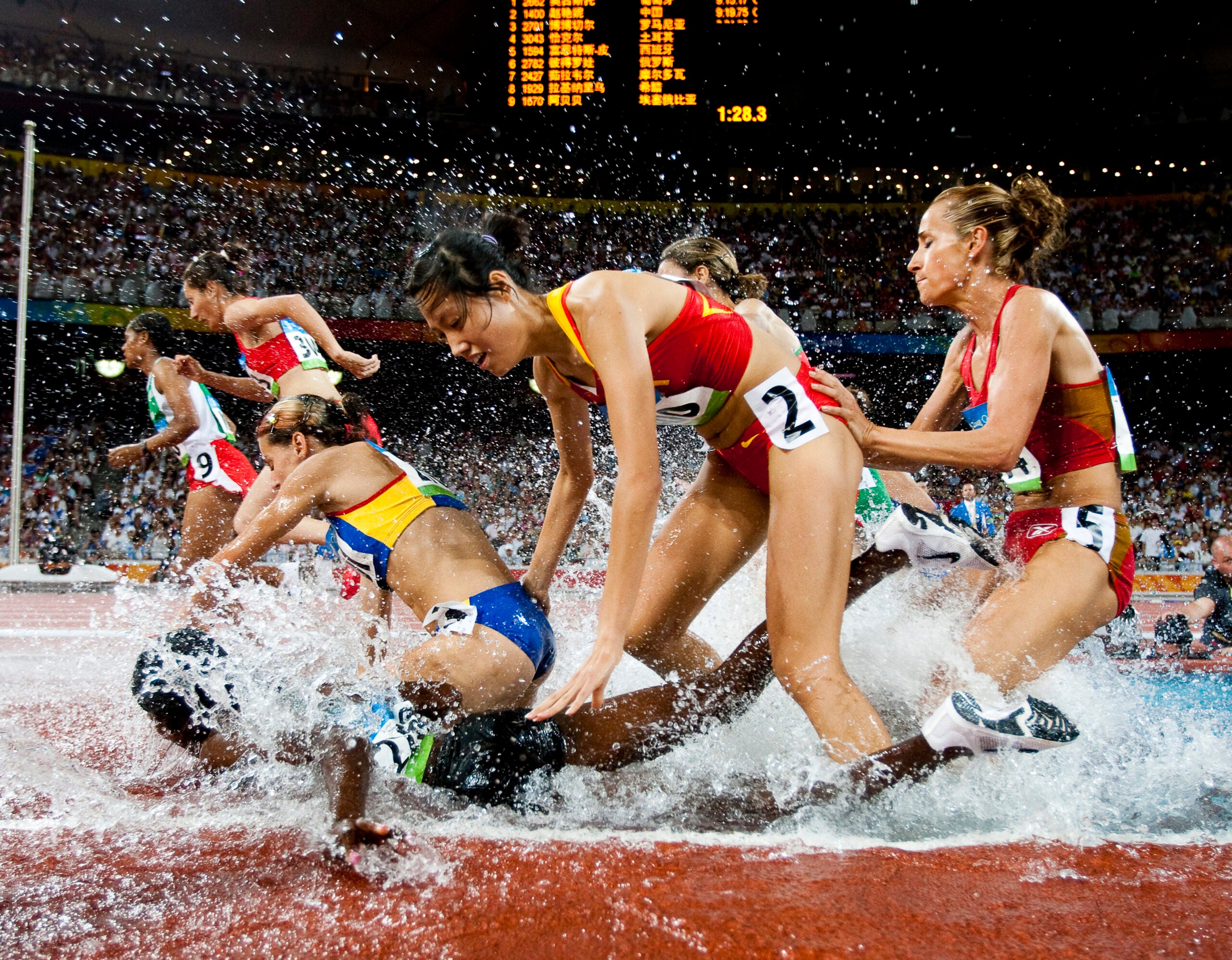 Runners splashing in the steeple chase pit.