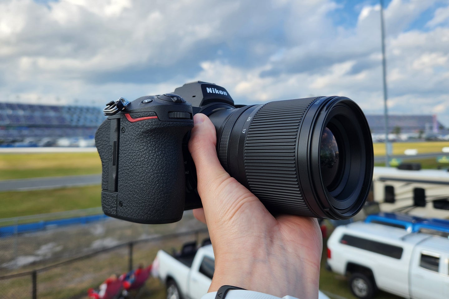 A Nikon camera held in front of a racetrack.