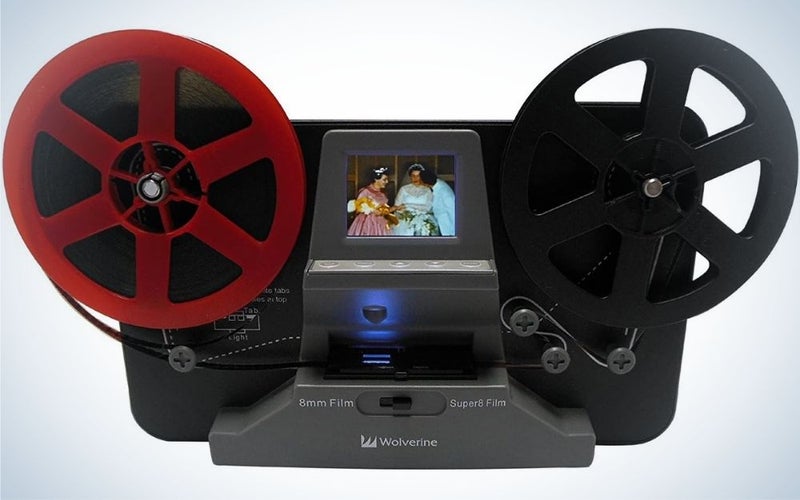 Um scanner conversor de bobina de filme para converter filme em vídeos digitais com duas rodas uma cor preta e uma cor vermelha, bem como no meio de uma tela pequena.