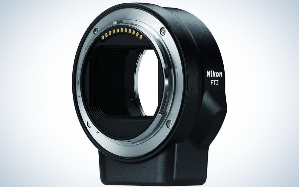 A black Kanon lens adapter all with an oval shape and empty space inside as well as a silver arched line.