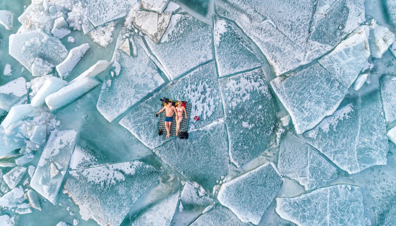 A couple lounges on ice hummocks in the Almaty region of Kazakhstan