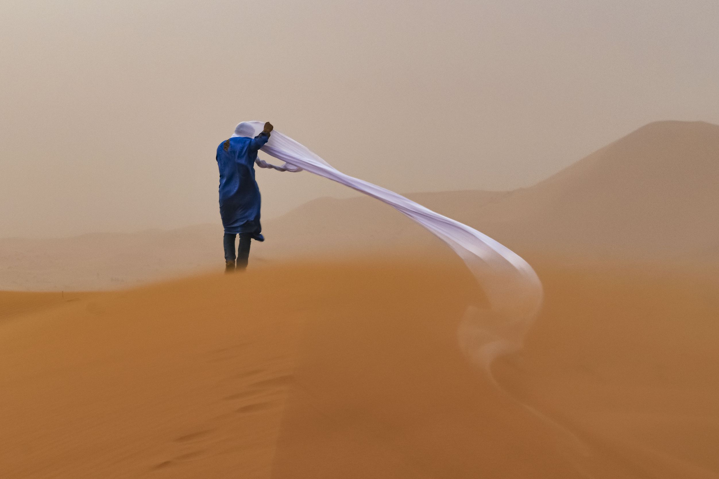 A guide in the Sahara Desert enduring a sand storm