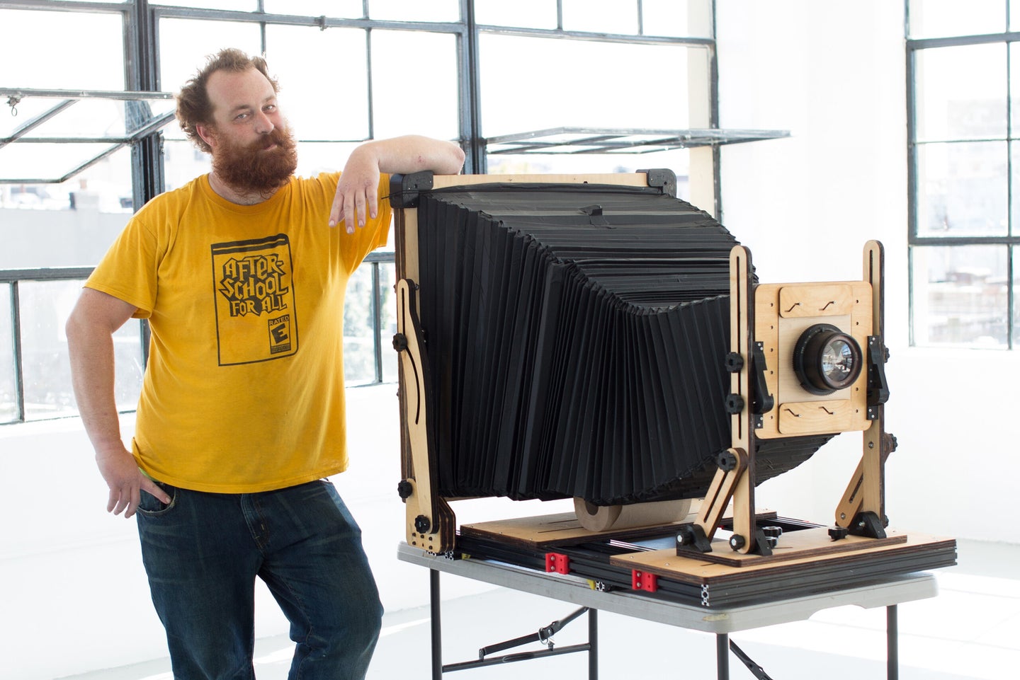 Ethan Moses standing next to his homemade giant instant camera.