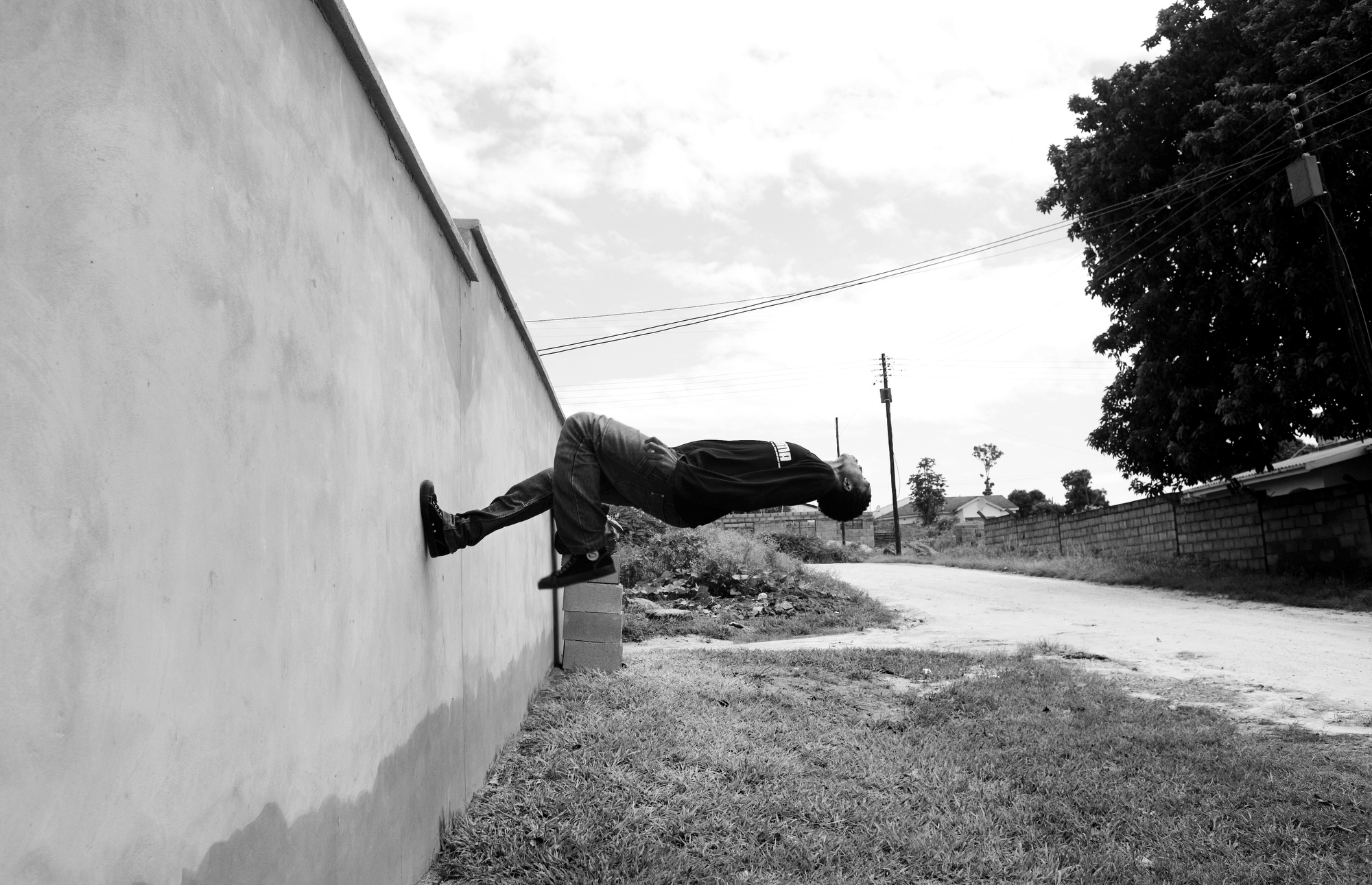 A teenager practices a flip off a wall in an urban neighborhood of eSwatini.