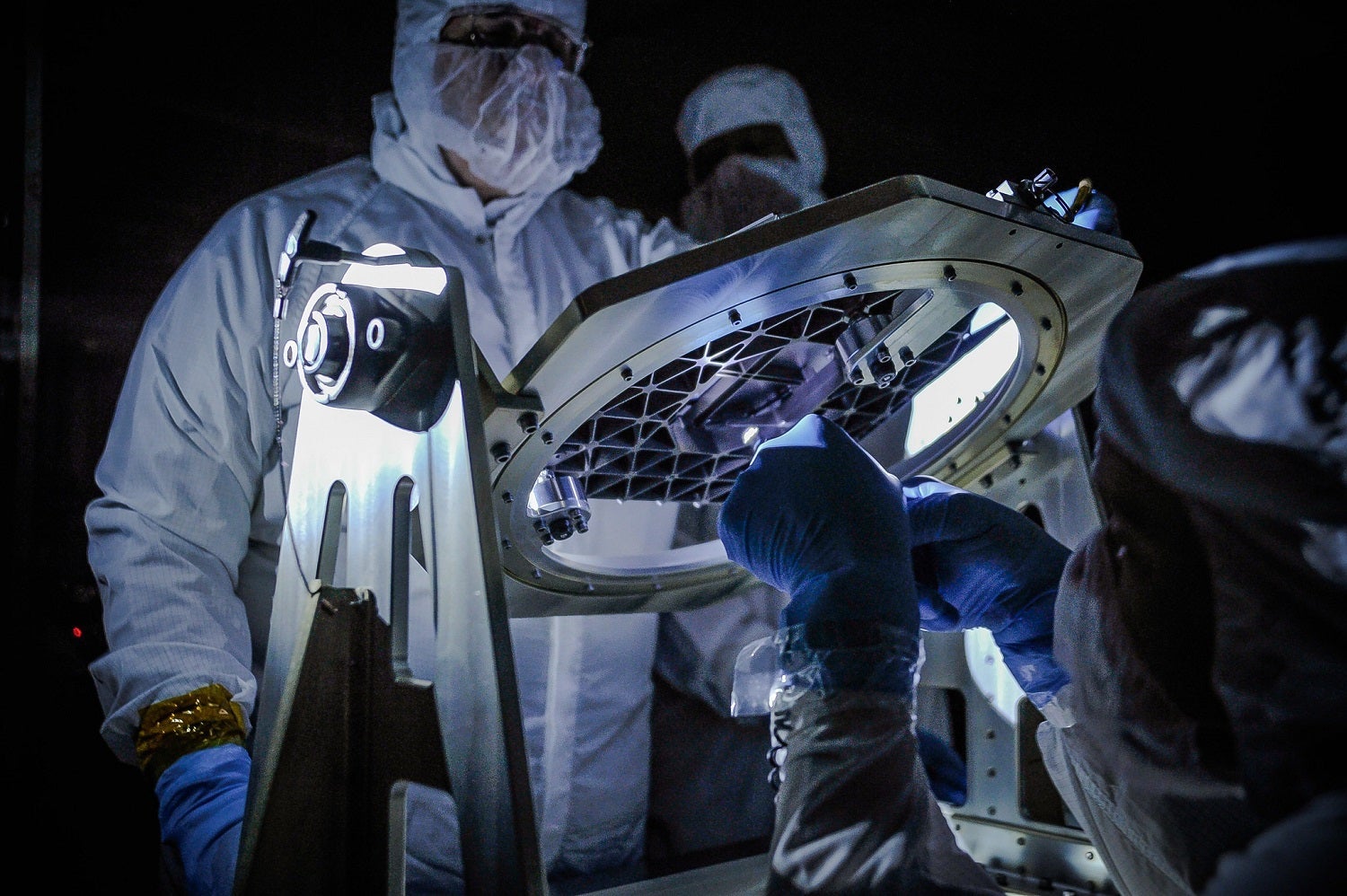 NASA engineers inspect a new piece of technology developed for the James Webb Space Telescope.