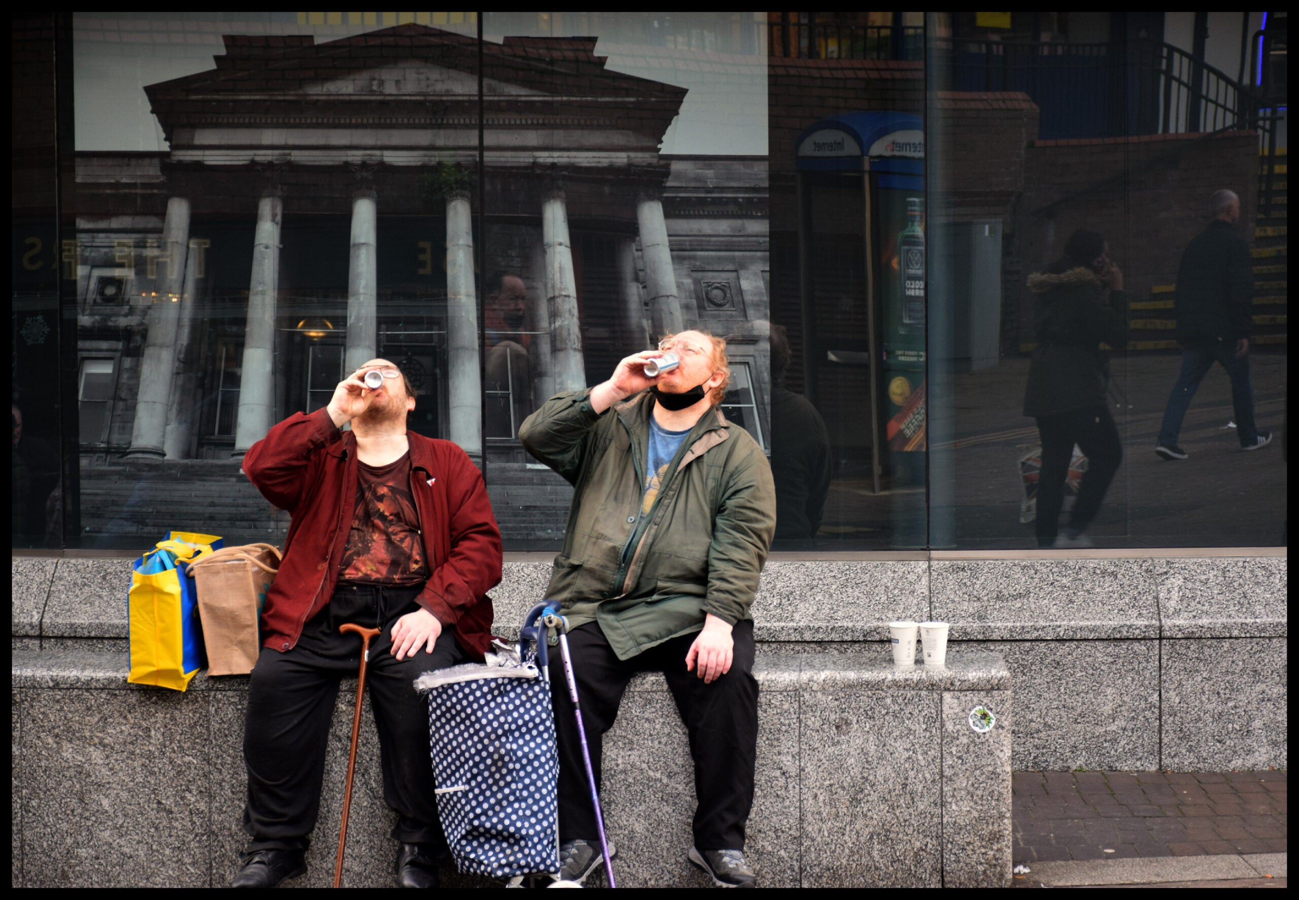 A candid shot of two people enjoying a beverage on the street