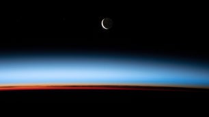 A crescent moon and sunset, captured from the ISS.