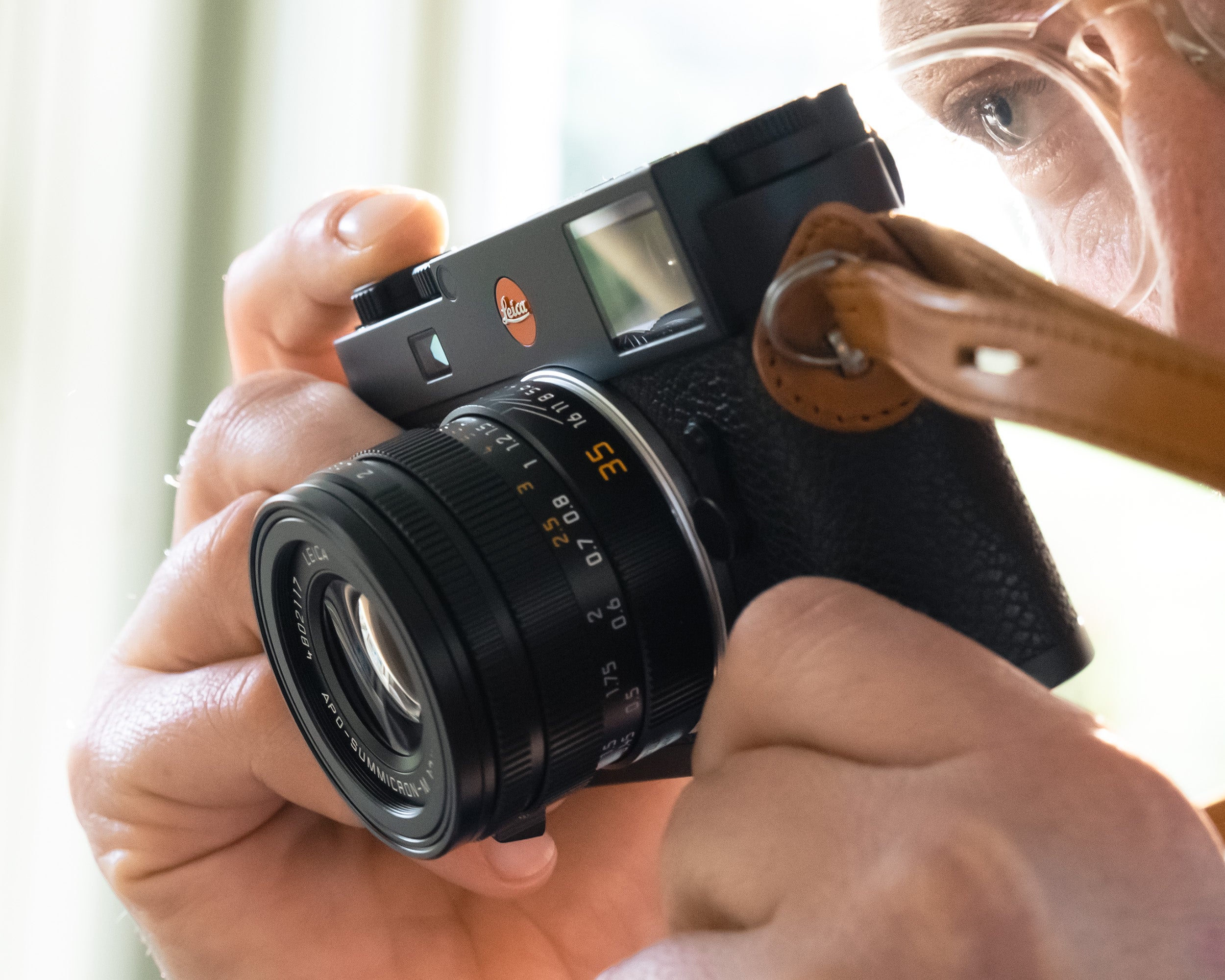 Leica M11 rangefinder camera held up to an eye