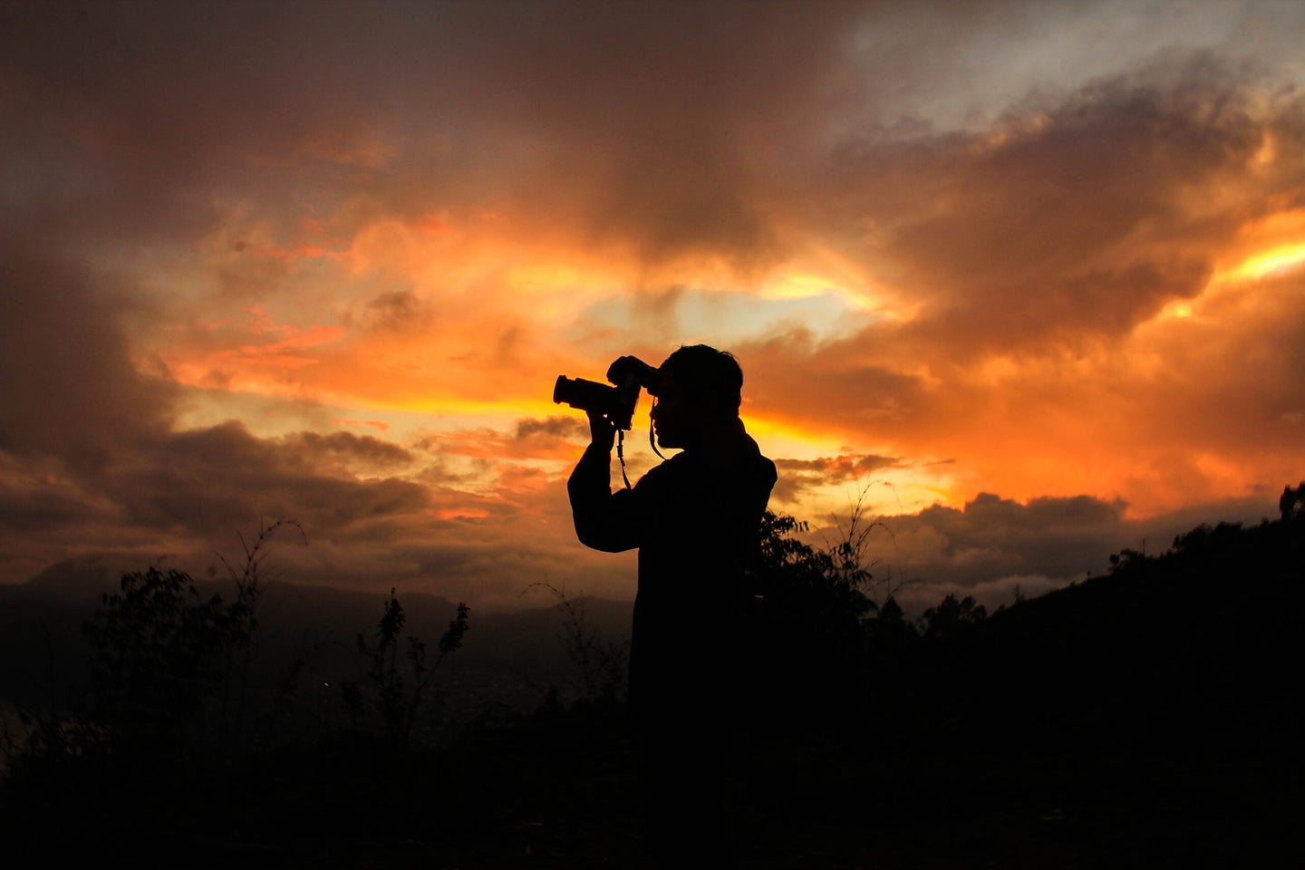 Silhouette Man Photographing Against Sky During Sunset - stock photo