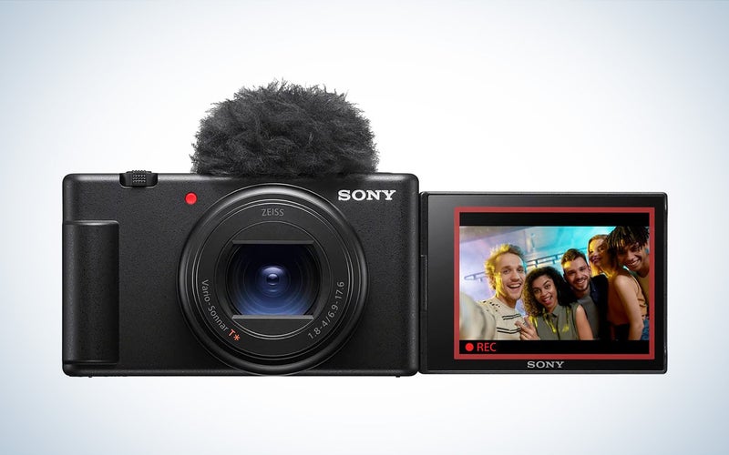 the black Sony ZV-1 II vlogging camera with screen flipped out and showing a group selfie against a white background