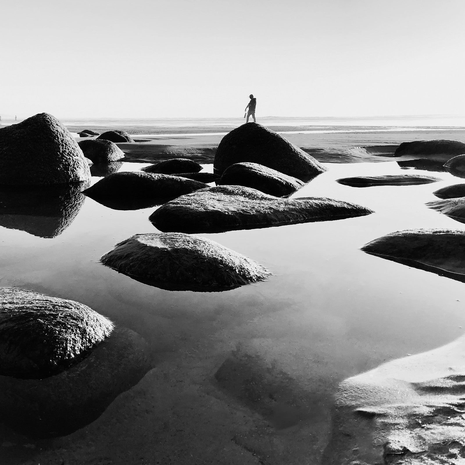 A monochrome image of rocks and the sea.