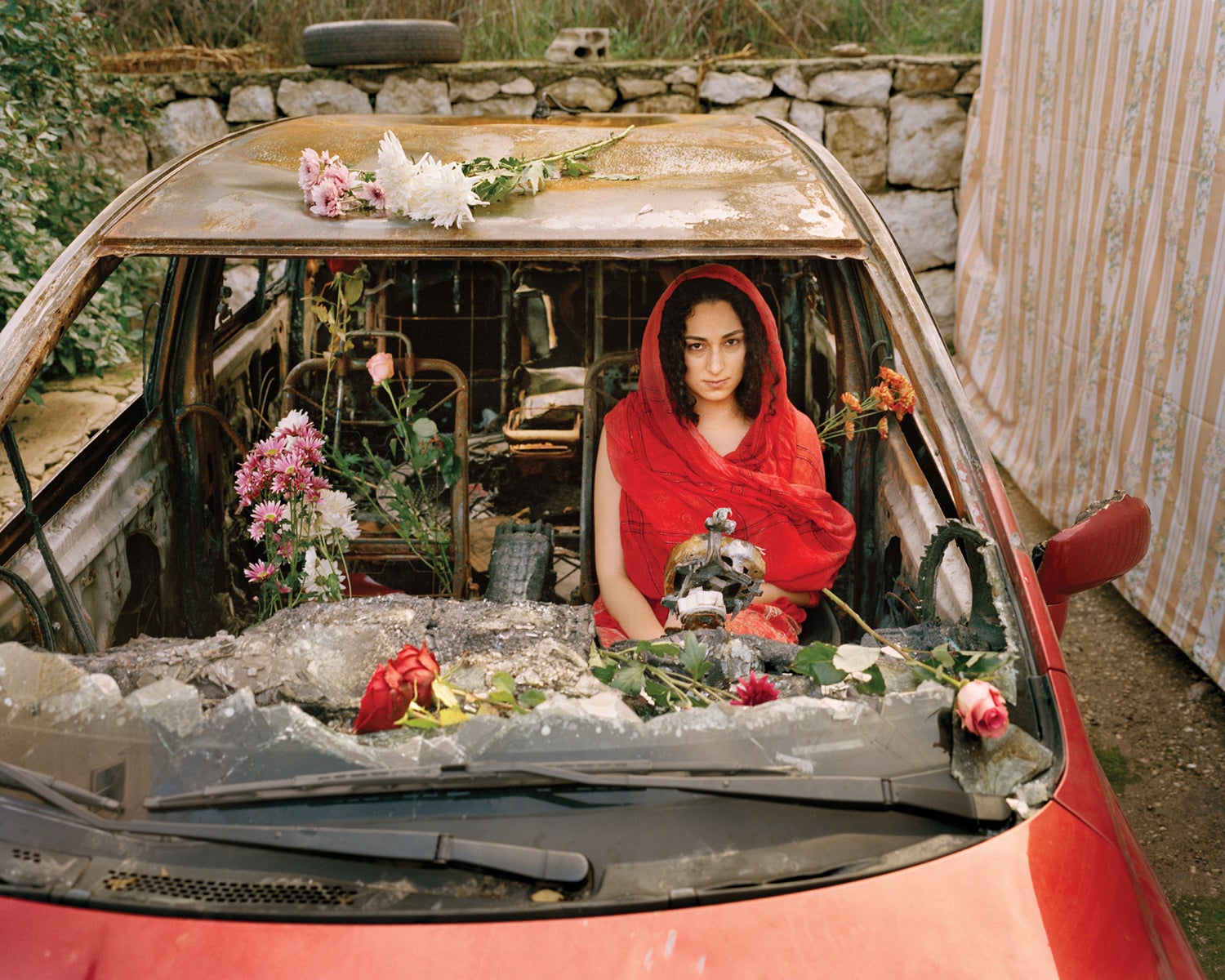Um retrato de uma mulher do Líbano em um carro destruído.