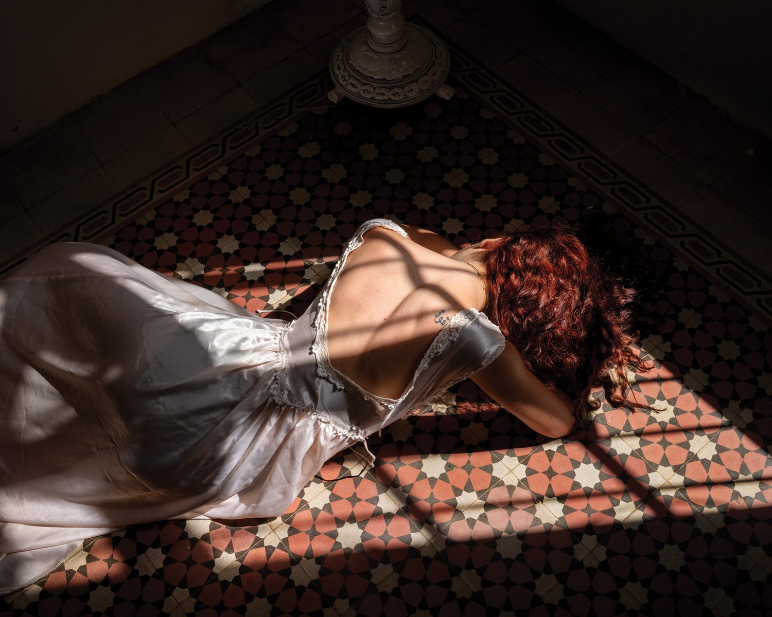 A portrait of a women from Lebanon laying on the floor int he sun.