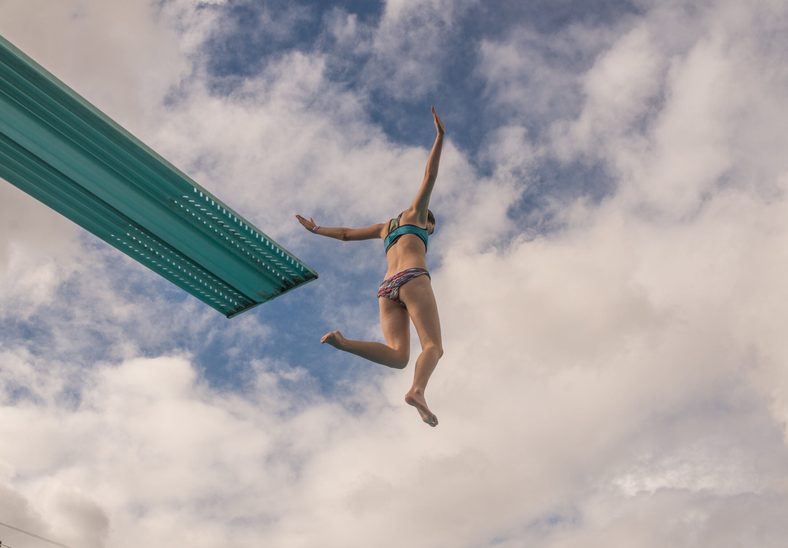 Uma mulher pulando de um trampolim.