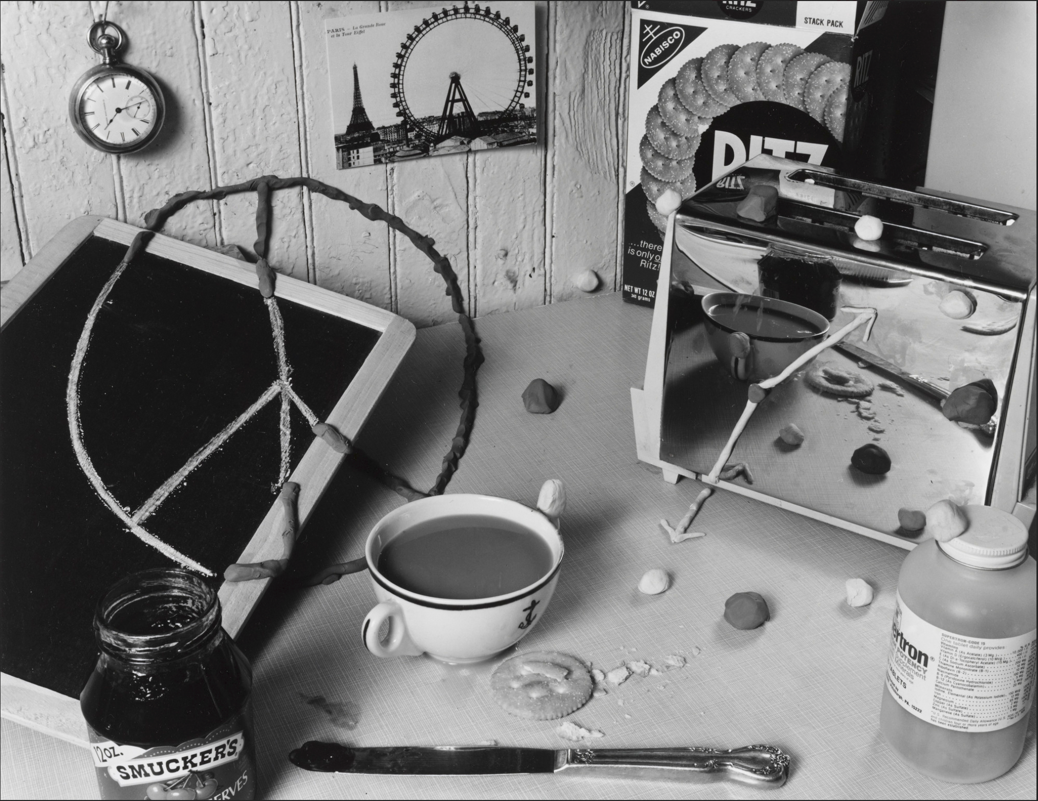 “Still Life with Peace Sign and Clockface, 1979,” by Zeke Berman. Gelatin silver print, 15 x 18 15/16 inches. 