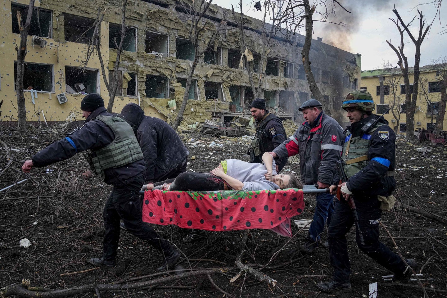 Ukrainian emergency employees and volunteers carry an injured pregnant woman from the damaged by shelling maternity hospital in Mariupol, Ukraine, Wednesday, March 9, 2022. A Russian attack has severely damaged a maternity hospital in the besieged port city of Mariupol, Ukrainian officials say.