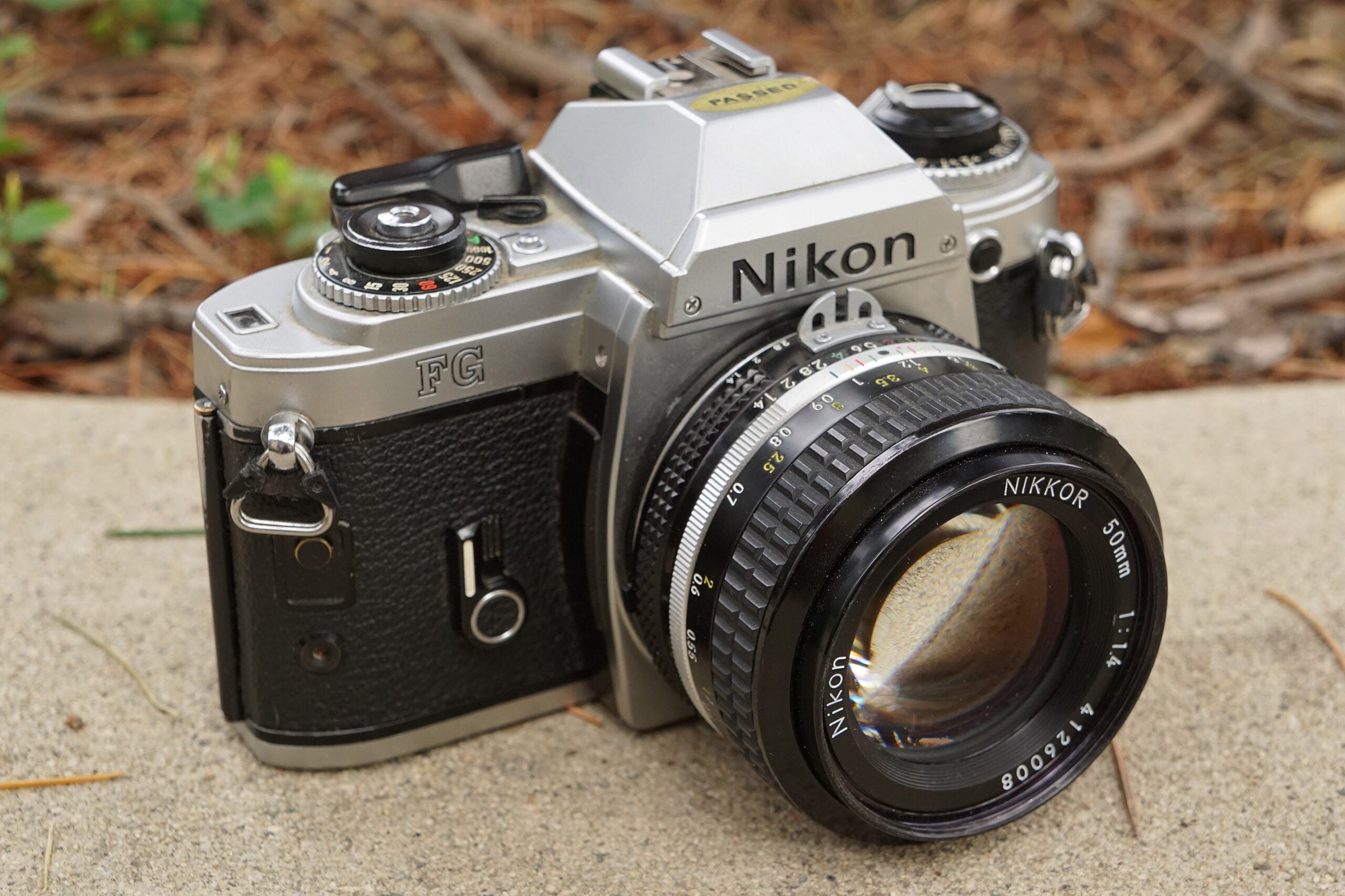 Uma câmera de filme Nikon FG 35mm em uma borda.