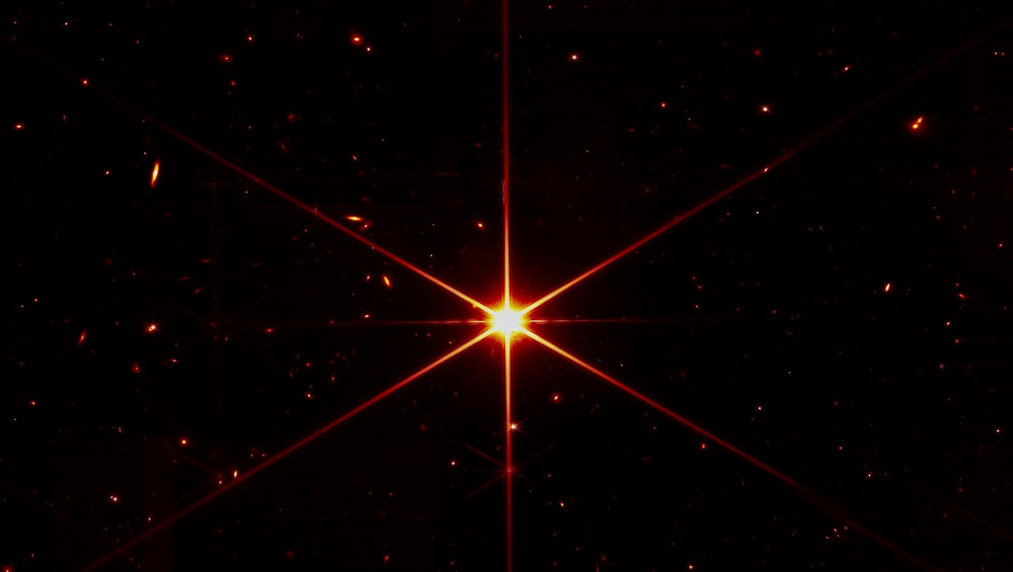 A bright star, with galaxies behind it, captured by the James Webb Space Telescope.