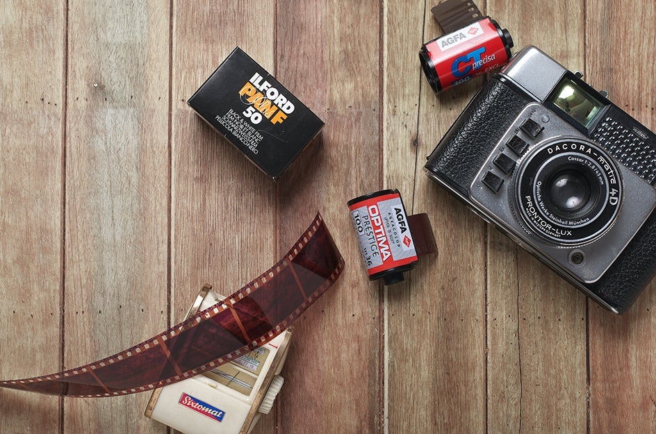 A camera on a table with rolls of film.