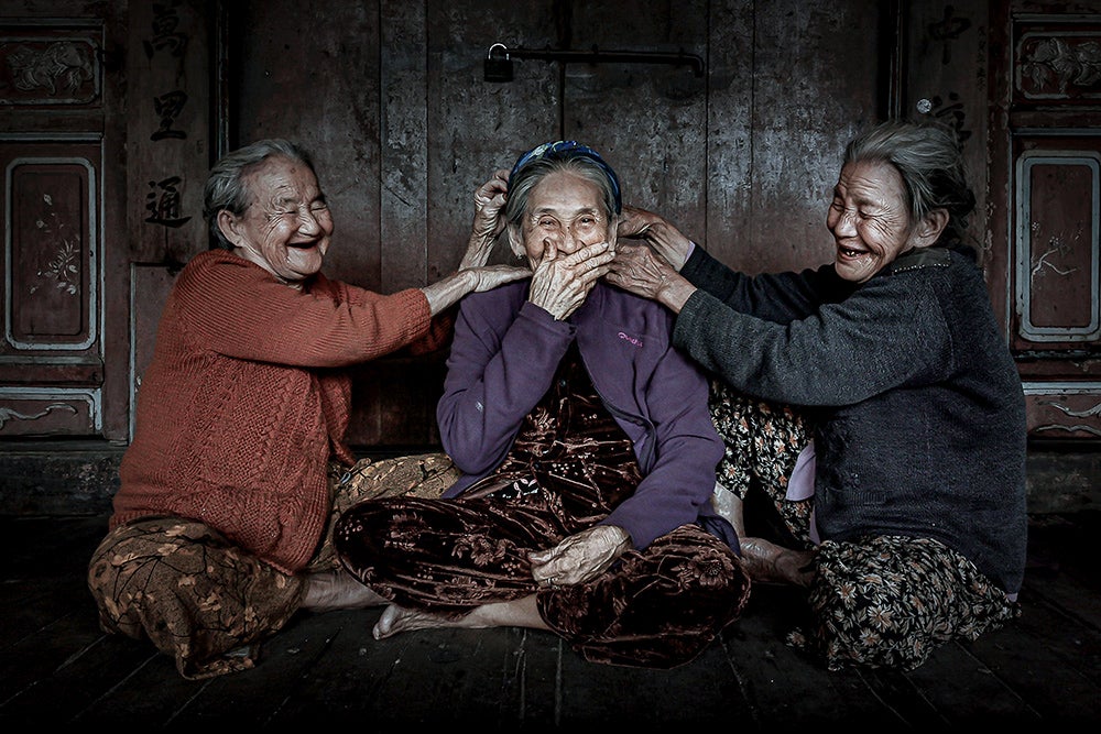 Three older women laughing with great joy.