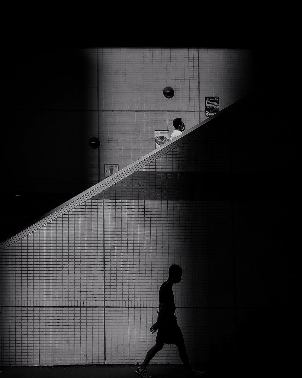 The silhouette of a man walking down the street.