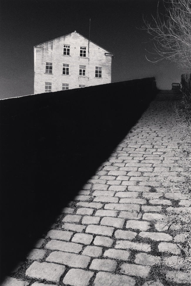 A black and white photo of a dark empty street.